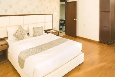 a bedroom with a large white bed in a room at Hillcrest Metro in Ooty