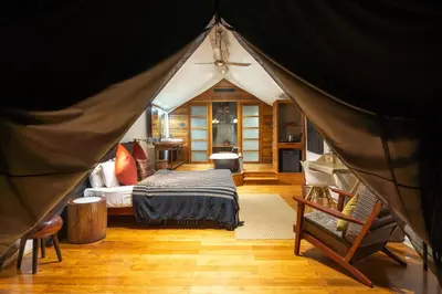 a bedroom with a bed in a tent at Kaav Safari Lodge, Kabini in Begūr