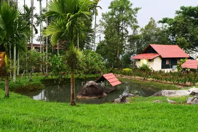a house and a pond in front of a yard at Avadale Wayanad - Stag Groups Not Allowed in Kalpetta