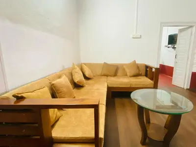 a living room with a couch and a glass table at Coorg Daffodil Guesthouse in Madikeri