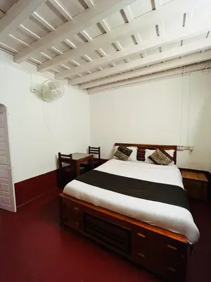 a bedroom with a large bed in a room at Coorg Daffodil Guesthouse in Madikeri