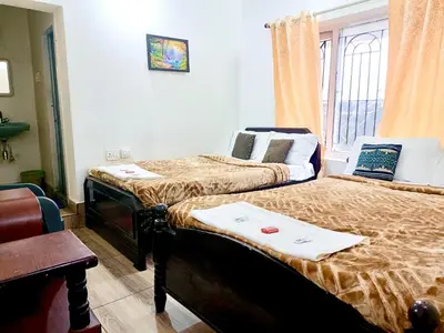 two beds in a room with a window at QUEENS COTTAGE - individual cottage in Ooty