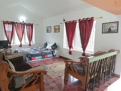 a living room with a bed and red curtains at QUEENS COTTAGE - individual cottage in Ooty