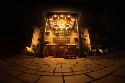 a building with lights on the front at night at Devasura inn in Guruvāyūr