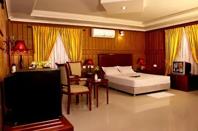 a bedroom with a bed and a table and chairs at Devasura inn in Guruvāyūr