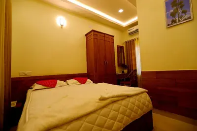a bedroom with a large bed with red pillows at SAPPHIRE INN in Nedumbassery