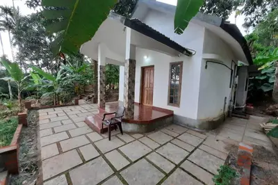a small white house with a patio at Wayal Wayanad Honey moon villa in Panamaram