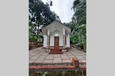 a small white house in the middle of a forest at Wayal Wayanad Honey moon villa in Panamaram