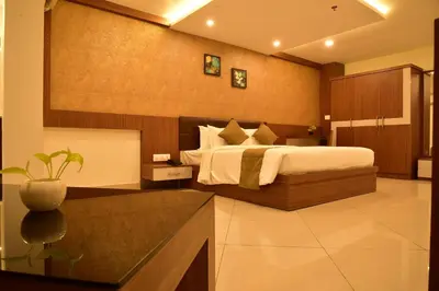a bedroom with a large bed in a room at WHITE SUITE HOTEL in Kozhikode