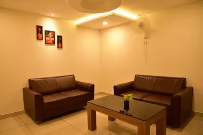 a living room with two couches and a coffee table at WHITE SUITE HOTEL in Kozhikode