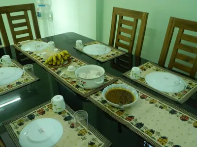a table with plates and bowls of food on it at ZaMaRaYa Bed & Breakfast in Angamali