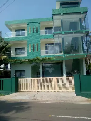 a green building with a fence in front of it at ZaMaRaYa Bed & Breakfast in Angamali