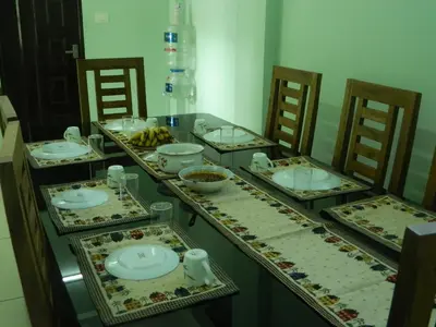 a table with plates and bowls of food on it at ZaMaRaYa Bed & Breakfast in Angamali