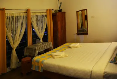 a bedroom with a bed and a window with a mirror at EDEN Paradisee in Ooty