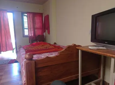 a small bedroom with a bed and a television at Dreams River view home stay coorg 2 in Kushālnagar