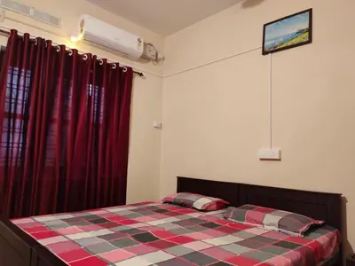 a bedroom with a bed with a checkered blanket at MALABAR Residency in Perintalmanna