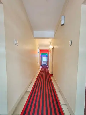 a red carpeted hallway with a long red carpeted corridor at MALABAR Residency in Perintalmanna