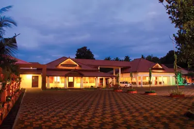 a large building with a courtyard at night at Clay House in Trichūr