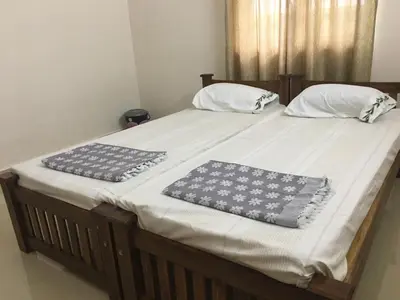 a large bed with two pillows on top of it at Shantham Service Apartments, Kinathukadavu, Coimbatore in Coimbatore
