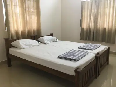 a bed with two towels on top of it at Shantham Service Apartments, Kinathukadavu, Coimbatore in Coimbatore