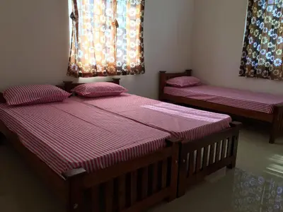 two beds in a room with purple sheets at Shantham Service Apartments, Kinathukadavu, Coimbatore in Coimbatore