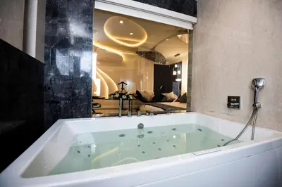 a large bath tub with a view of a living room at Hotel Park Elanza Coimbatore in Coimbatore