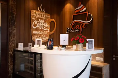 a counter in a restaurant with a coffee cafe sign at Hotel Park Elanza Coimbatore in Coimbatore