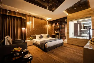 a bedroom with a bed and a couch and a window at Hotel Park Elanza Coimbatore in Coimbatore