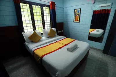 a bedroom with a large bed with yellow and white pillows at NARMADA HOMESTAY Yamuna in Malappuram
