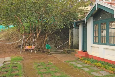 a house with a tree and a swing at HS Holiday Home in Coonoor