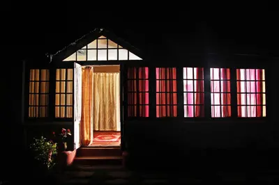an open door of a house with colorful windows at HS Holiday Home in Coonoor