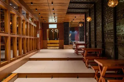 a restaurant with wooden walls and wooden tables and benches at Nexstay Treats Inn in Kozhikode