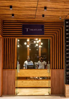 two men standing in the doorway of a treats inn at Nexstay Treats Inn in Kozhikode