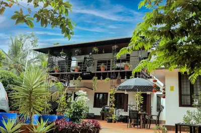 a house with a balcony with plants at Aldora Holiday Homes in Vythiri