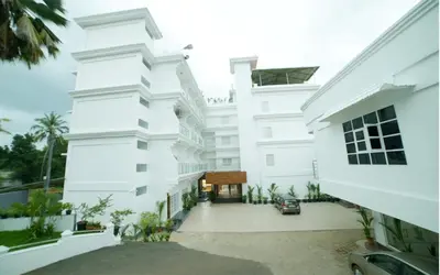 an exterior view of a white building at HOTEL SURYA in Iritti