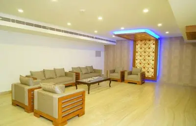 a living room with couches and chairs and a table at HOTEL SURYA in Iritti