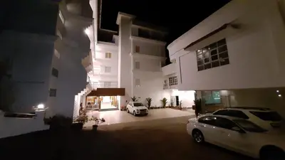 two cars parked in front of a building at night at HOTEL SURYA in Iritti