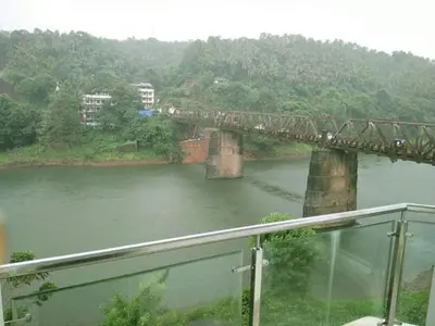a train crossing a bridge over a river at HOTEL SURYA in Iritti