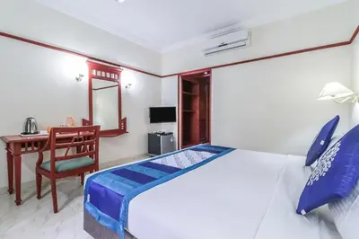 a bedroom with a bed and a desk and a chair at Fort Gate Hotels & Resorts in Trichūr