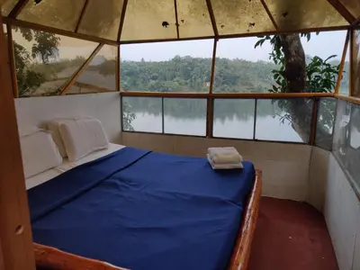 a bed in a room with a large window at 7 Heaven Resorts in Ambalavayal