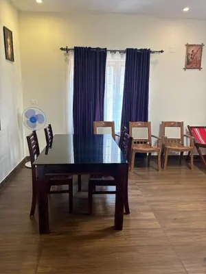 a dining room with a wooden table and chairs at Casa Felicia-Adding happy moments to your diary in Ooty