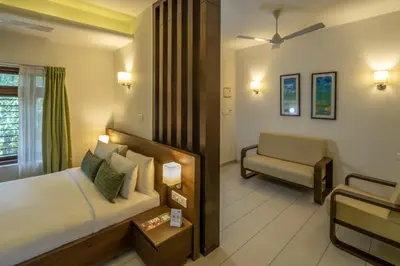 a hotel room with a bed and a couch at The Woods Resorts Wayanad in Sultan Bathery