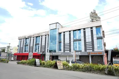 a building with signs in front of it on a street at Sri Krishnan Residency in Pollāchi