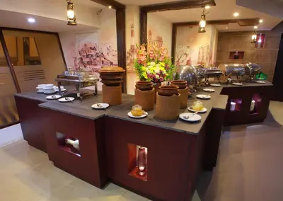 a row of tables with food and flowers on them at Manuelsons Malabar Palace in Kozhikode