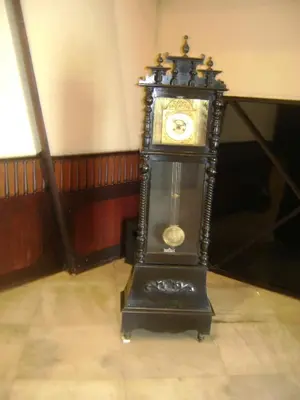 a grandfather clock sitting on the floor in a room at Manuelsons Malabar Palace in Kozhikode