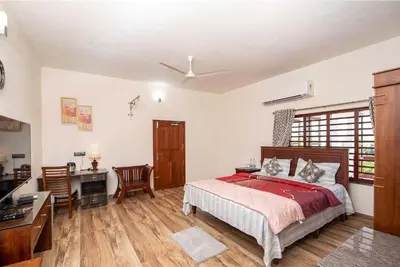 a bedroom with a bed and a desk and a desk at StayVista at Springhills Villa & Ayurvedic Spa in Cochin