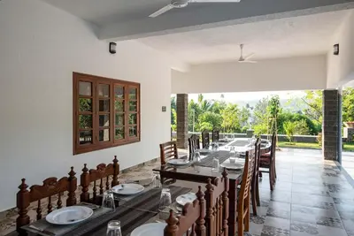 a long dining room with a long table and chairs at StayVista at Springhills Villa & Ayurvedic Spa in Cochin