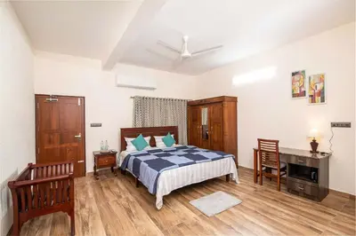 a bedroom with a bed and a desk in it at StayVista at Springhills Villa & Ayurvedic Spa in Cochin