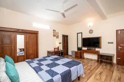 a bedroom with a bed and a flat screen tv at StayVista at Springhills Villa & Ayurvedic Spa in Cochin