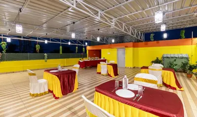 a banquet hall with tables and chairs in a room at Treebo Four Seasons in Mysore